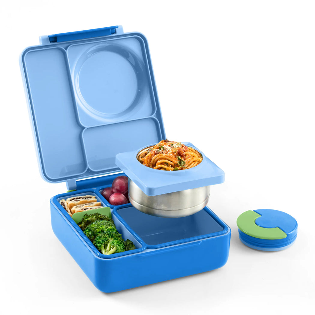 Blue bento box with compartments containing food on a white background