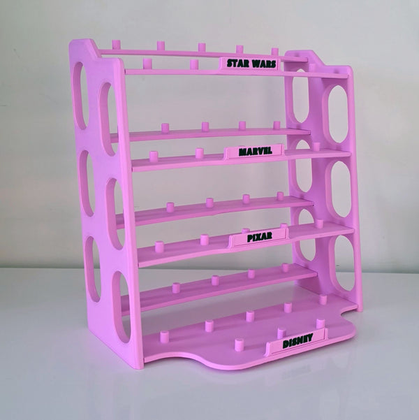 A pink plastic movie theater popcorn display stand with shelves labeled for Star Wars, Marvel, Pixar, and Disney, set against a plain light gray background.