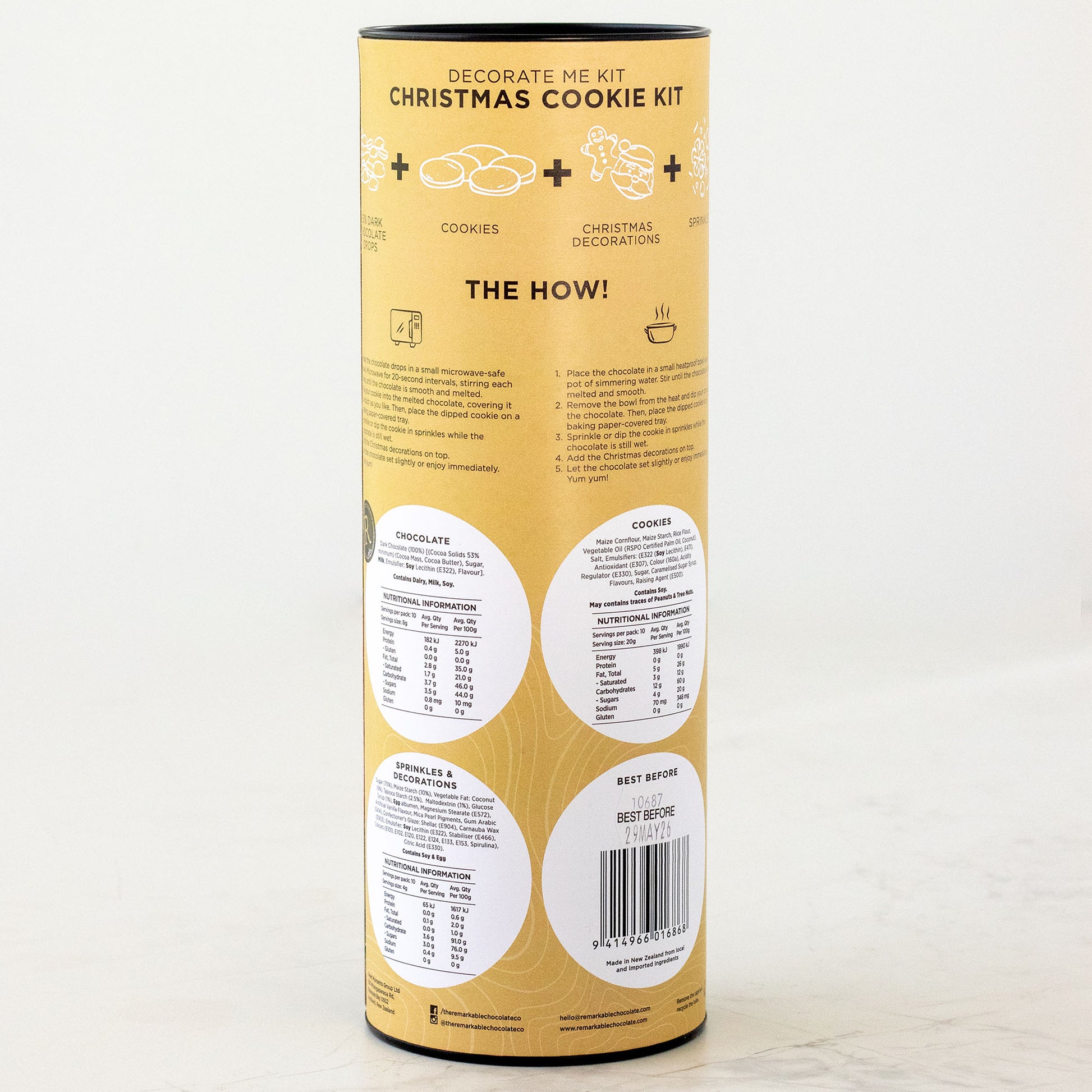 Yellow cylindrical packaging for a Christmas cookie kit on a white background