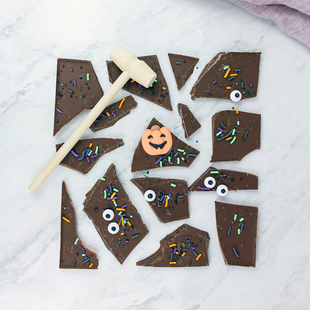 Chocolate bark with Halloween decorations on a white marble surface