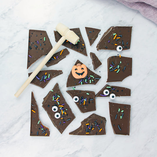 Chocolate bark with Halloween decorations on a white marble surface