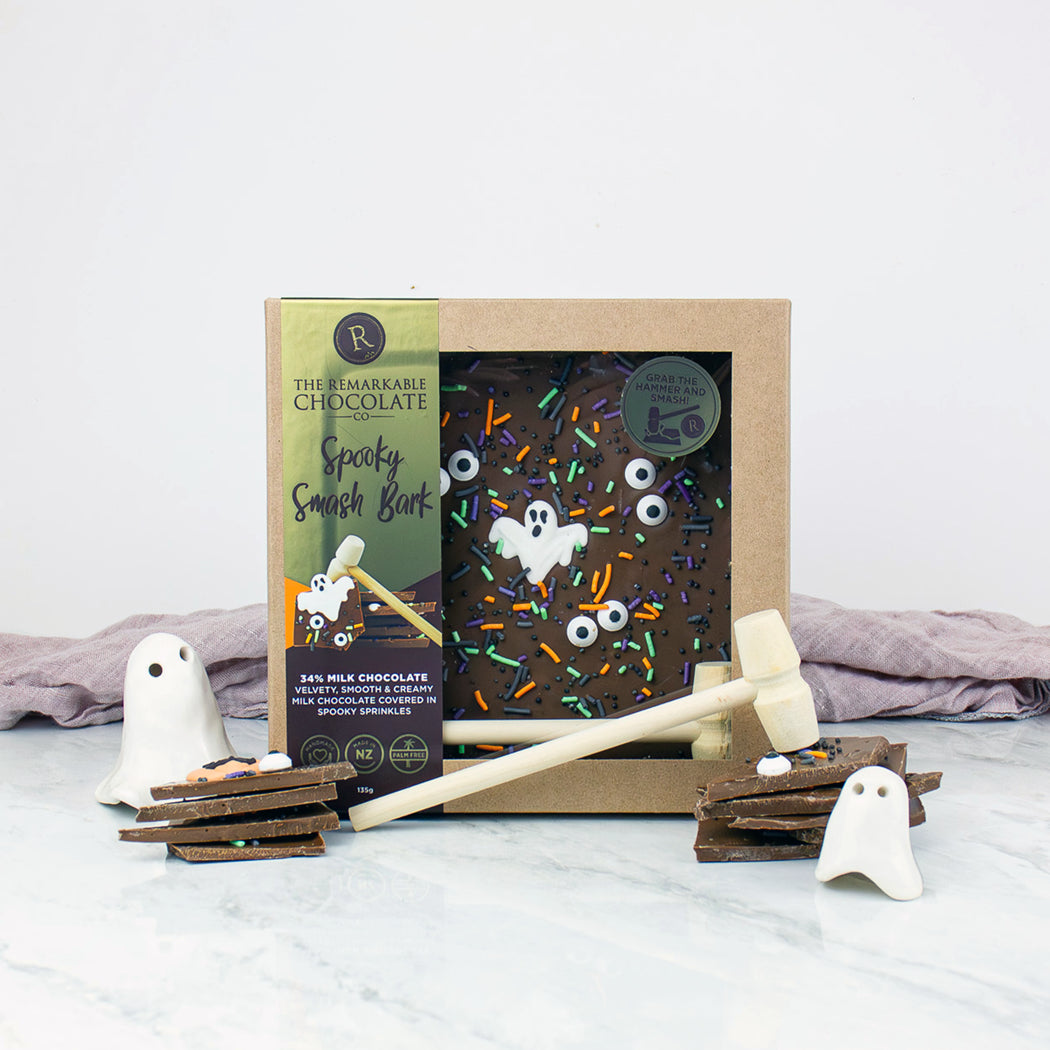 Halloween-themed chocolate product with a mallet and ghost decorations on a white surface.