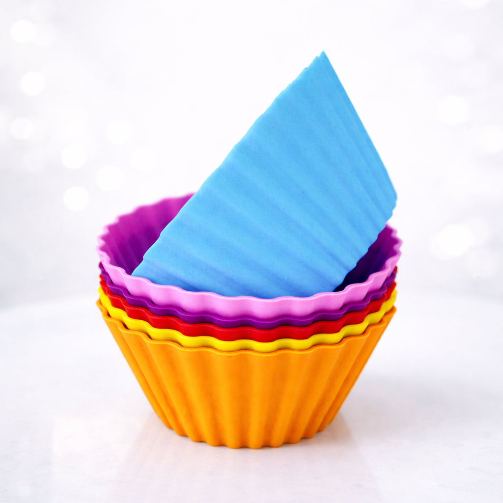 Set of colorful silicone baking cups on a white background