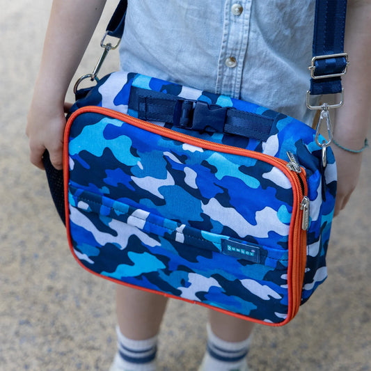 Blue camouflage bag with orange accents held by a person