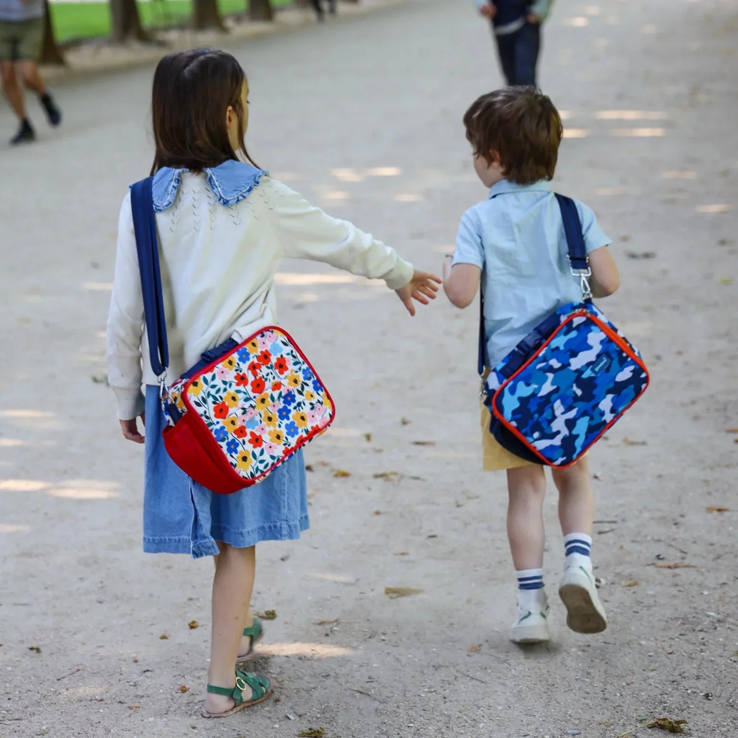 Two children walking outdoors with colorful backpacks