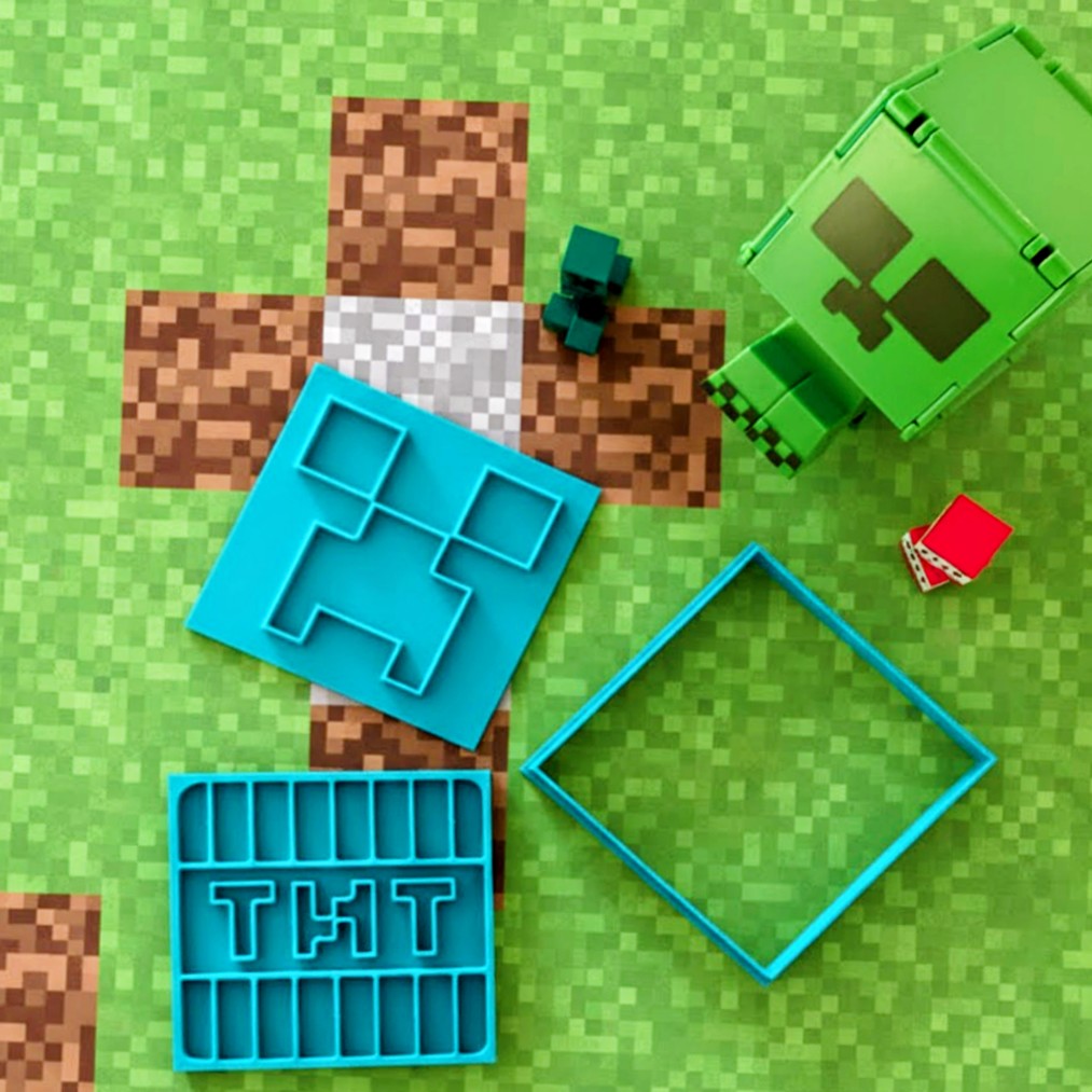 Toy figures and cookie cutters on a green pixelated background
